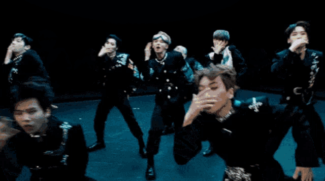 a group of young men are dancing in front of a large blue moon