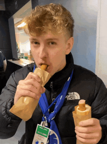 a young man wearing a north face jacket is eating something
