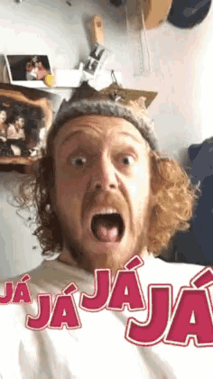 a man with a beard is making a funny face with the word jaja on his shirt