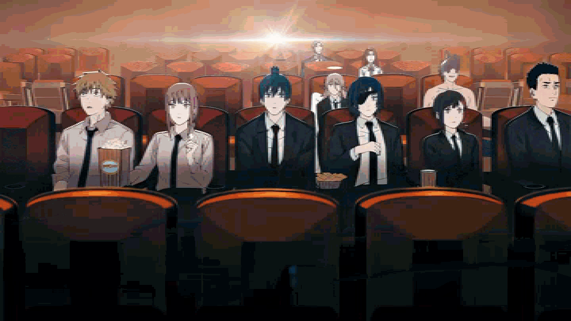 a group of people are sitting in a theater with a box of popcorn