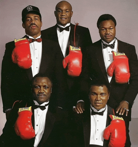 a group of men wearing tuxedos and boxing gloves one of which has the word reyes on it