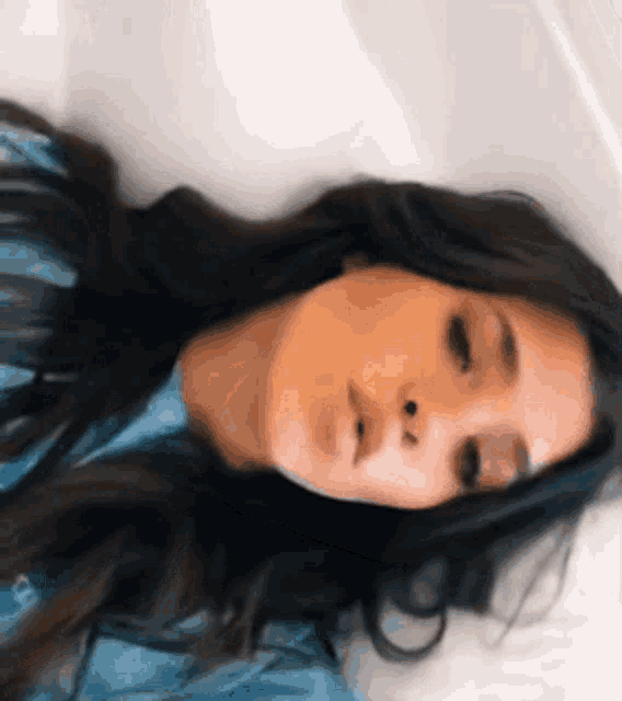 a woman laying down with her eyes closed and her mouth open