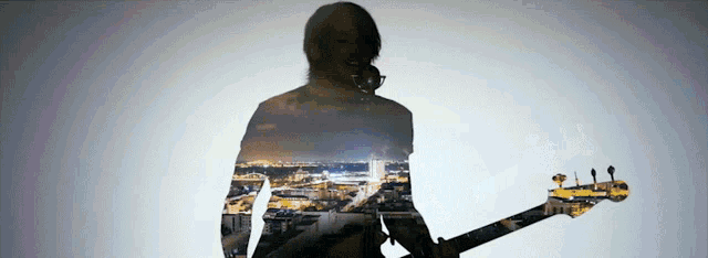 a double exposure of a person playing a guitar
