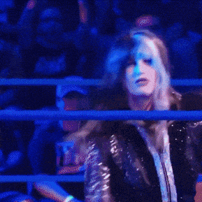 a woman in a fur coat is standing in a boxing ring