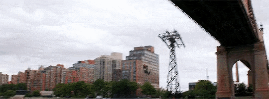a bridge with a city in the background and a telephone pole in the foreground