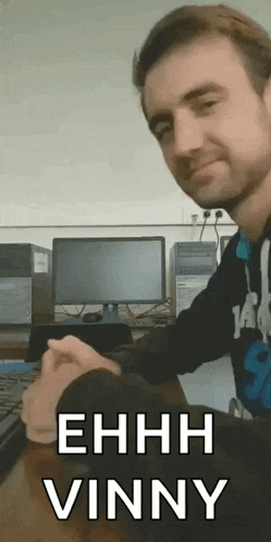 a man sitting in front of a computer with the words ehhh vinny written below him