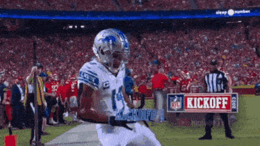 a football player with the number 14 on his jersey runs on the field