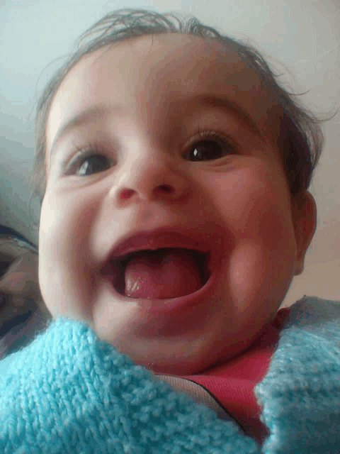 a baby is smiling with his tongue out