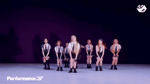 a group of girls are performing a dance in front of a performance 37 logo