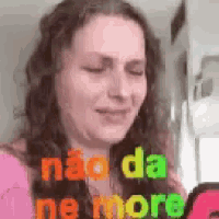 a woman is crying while looking at a cell phone with the words não da ne more written on her face .