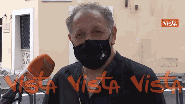 a man wearing a mask is being interviewed by a vista news channel