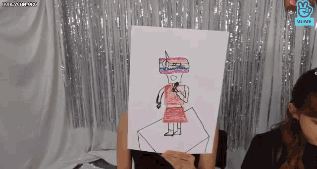a woman is holding up a drawing of a woman with a microphone in her hand .