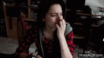a woman in a plaid shirt is sitting in a chair holding a piece of paper in her hand ..