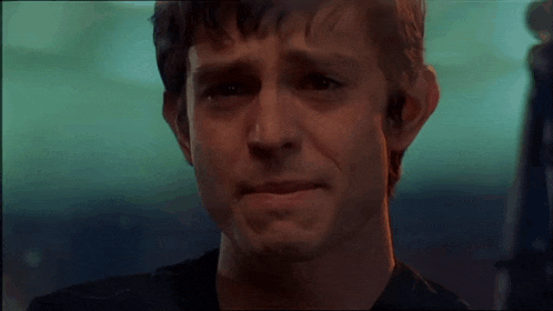 a close up of a man 's face with a tear running down his face .