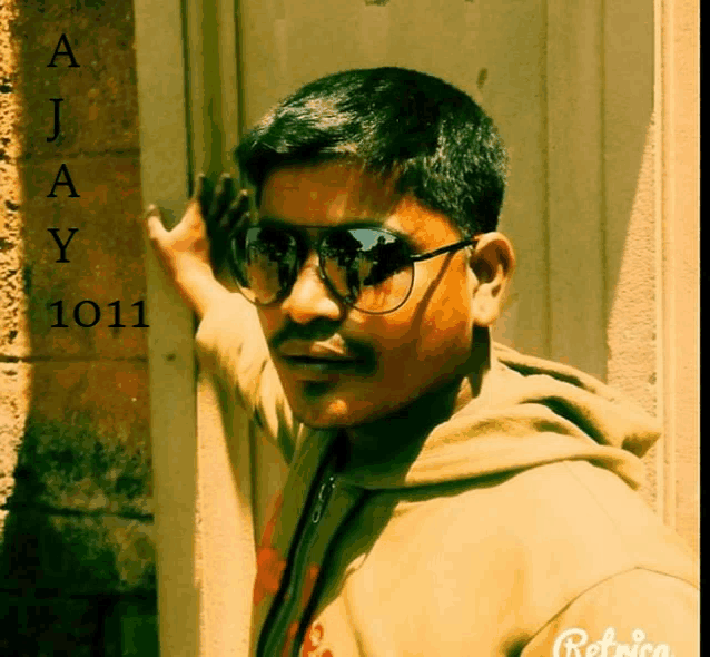 a young man wearing sunglasses is standing in front of a wall with the number 1011 written on it