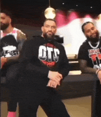 a group of men are standing next to each other and dancing in a room .