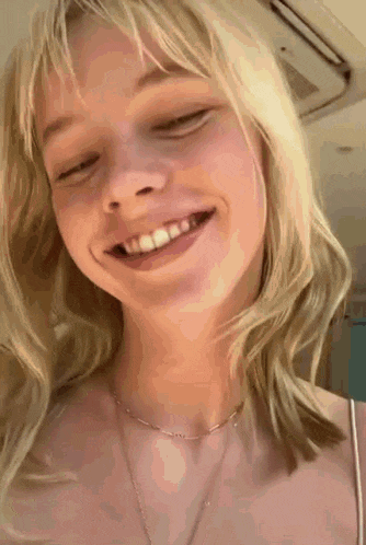 a close up of a woman 's face with her eyes closed and smiling .