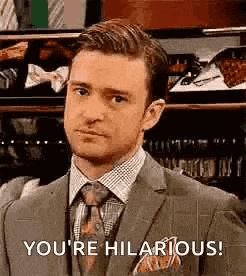 a man in a suit and tie is making a funny face and saying `` you 're hilarious ! ''