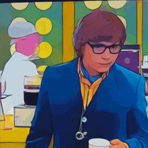 a man in a blue suit and glasses holds a cup