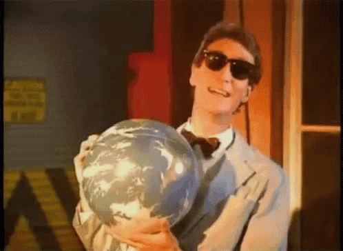 a man in sunglasses holds a globe in his hands