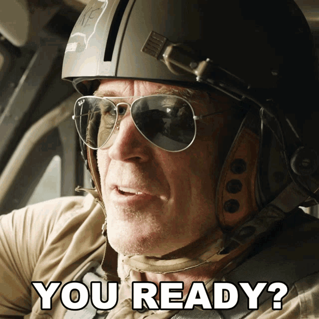 a man wearing a helmet and sunglasses is asking if he 's ready