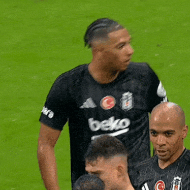 a soccer player wearing a black beko shirt