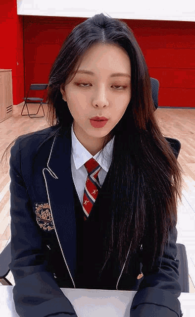 a girl wearing a suit and tie is making a face