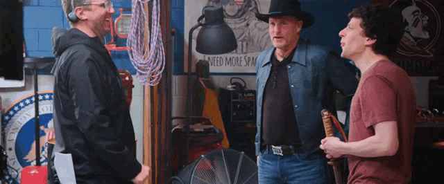 a man in a cowboy hat talks to two other men