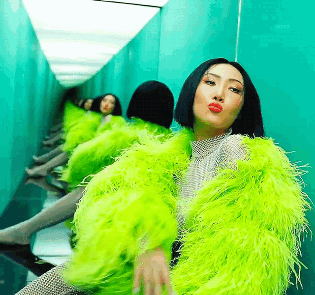 a woman wearing a neon green fur coat is sitting in a hallway .