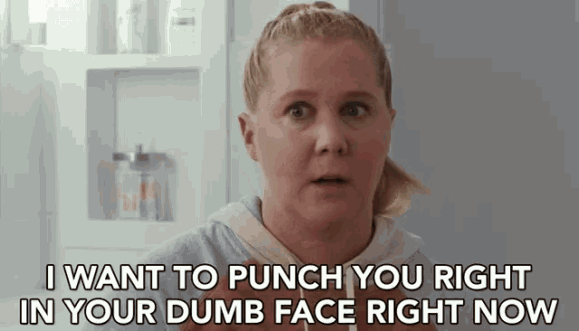 a woman is making a funny face and saying `` i want to punch you right in your dumb face right now ''