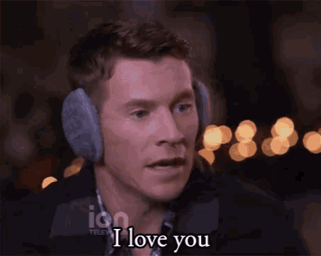 a man wearing ear muffs is saying i love you