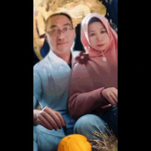 a man and woman posing for a picture with a pumpkin in the foreground