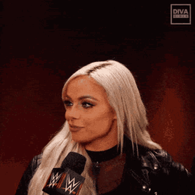 a woman is talking into a wwe microphone .