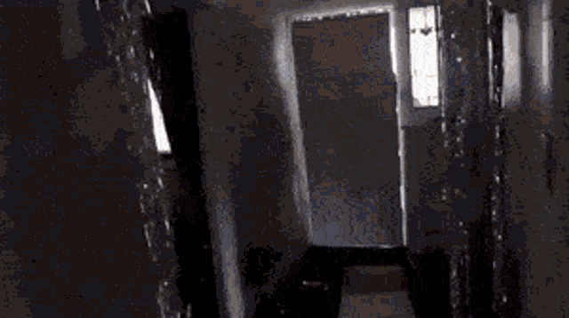 a man is carrying a large piece of furniture in a hallway