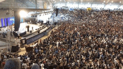 a large crowd of people are gathered in a stadium with a sign that says sonhos