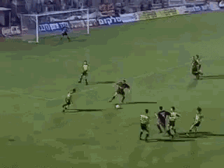 a group of soccer players are playing a game of soccer on a field with advertisements on the sidelines .