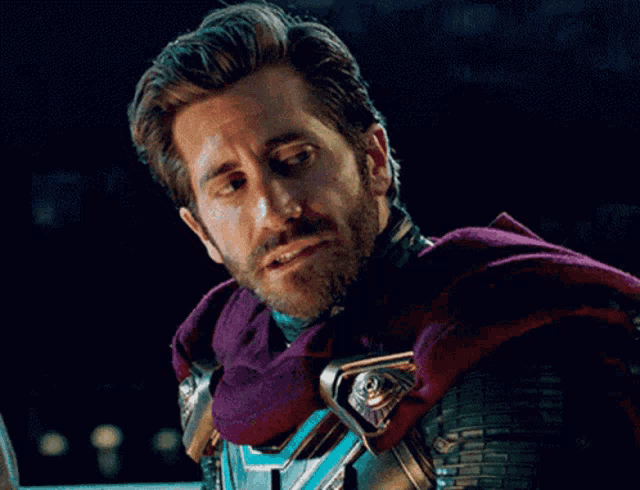 a man with a beard wears a purple cape