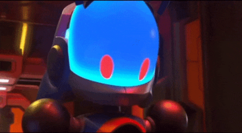 a robot with a sad face is sitting in front of a computer screen .