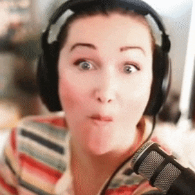 a woman wearing headphones and a microphone making a face
