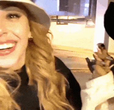 a woman wearing a white hat is smiling and holding something in her hand