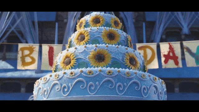 a large birthday cake with sunflowers on it