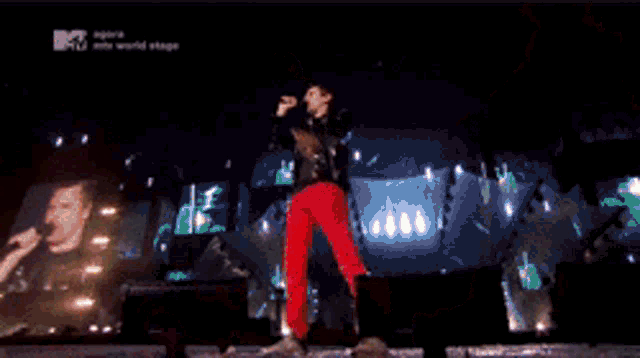 a man singing on a stage with a mtv logo behind him