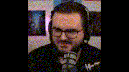 a man with glasses and headphones is sitting in front of a microphone .