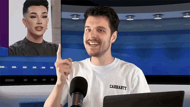 a man wearing a carhartt t-shirt points at a woman