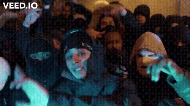 a group of people wearing face masks and hoodies are dancing in a room .