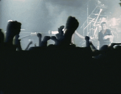 a crowd of people with their hands in the air