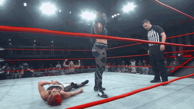 a wrestler is laying on the ground in a wrestling ring