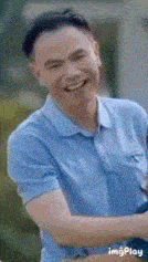 a man in a blue shirt is smiling and looking at the camera with imgplay in the corner