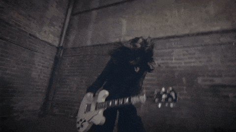 a person playing a guitar in a dark room