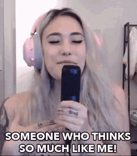 a woman wearing headphones is singing into a microphone and says `` someone who thinks so much like me '' .